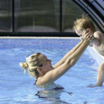 A Woman Holding Her Baby Inside a Pool